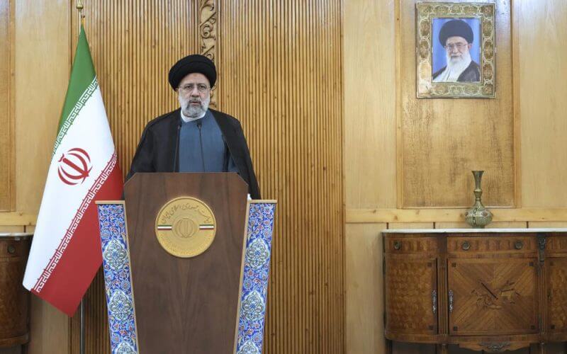 Iranian President Ebrahim Raisi speaks prior to departing Tehran's Mehrabad airport for a trip to Oman, Monday, May, 23, 2022. A portrait of the Supreme Leader Ayatollah Ali Khamenei hangs on the wall. (AP Photo/Vahid Salemi)