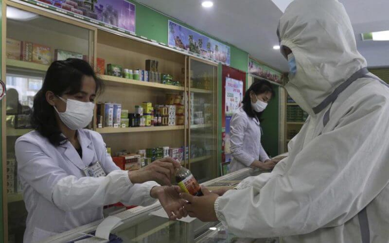 An employees of the Medicament Management Office of the Daesong District in Pyongyang provides medicine to a resident as the state increases measures to stop the spread of illness in Pyongyang, North Korea, Monday, May 16, 2022. (AP Photo/Jon Chol Jin)