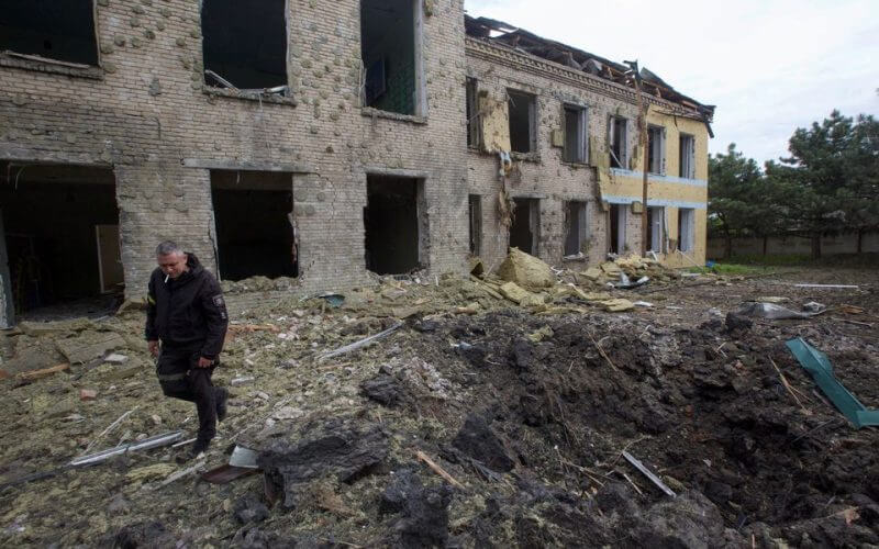 A police officer walks next to a school building damaged by a Russian military strike, as Russia's attack on Ukraine continues, in the settlement of Kostiantynivka, in Donetsk region, Ukraine May 22, 2022. Picture taken May 22, 2022. REUTERS/Anna Kudriavtseva