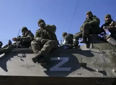 Russian military and pro-Russian separatists keep watch as civilians are being evacuated along humanitarian corridors from the Ukrainian city of Mariupol on March 24, 2022. (Stringer/Anadolu Agency via Getty Images)