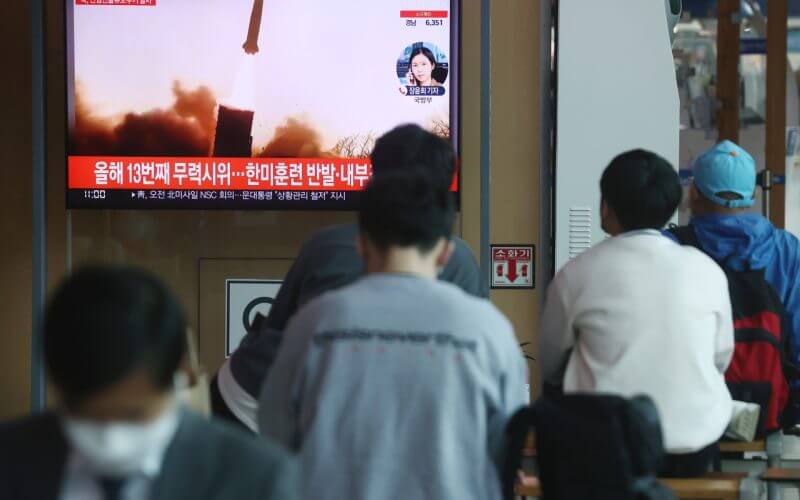 Passersby watch a TV report of North Korea’s missile launch at Seoul Station. (File Photo - Yonhap)