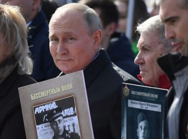 Russian President Vladimir Putin and other participants carry portraits of their relatives — World War II soldiers — as they take part in the Immortal Regiment march on May 9, 2022, in Red Square in central Moscow. Russia celebrates the 77th anniversary of the victory over Nazi Germany in World War II. (Natalia Kolesnikova/AFP via Getty Images)