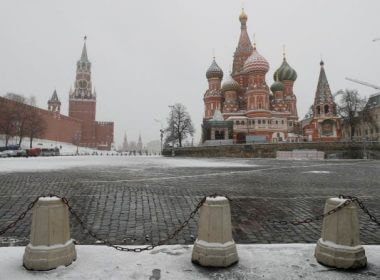 The clock on Spasskaya tower showing the time at noon, is pictured next to Moscow?s Kremlin, and St. Basil?s Cathedral, March 31, 2020. Photo: Reuters / Maxim Shemetov
