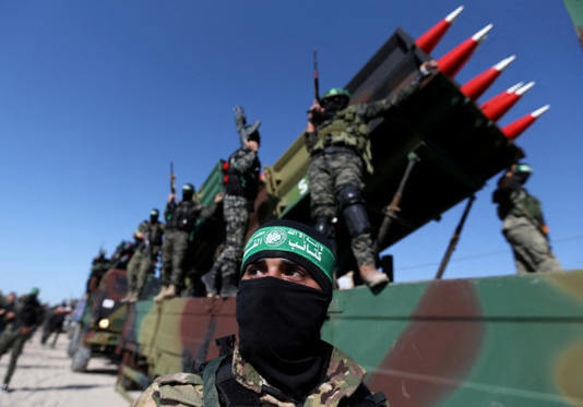 Palestinian Hamas terrorists attend an anti-Israel rally in Khan Younis, in the southern Gaza Strip May 27, 2021