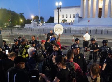 A.J. Hurley (rear left), Rev. Patrick Mahoney (rear left center), Pastor Mark Lee Dickson (rear right center), and Bryan Kemper(rear right), stand in front of the Supreme Court while surrounded by police and protestors on May 4, 2022. (Jackson Elliott/The Epoch Times)