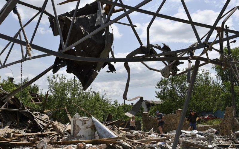 People clean an area of a building damaged by an overnight missile strike in Sloviansk, Ukraine, Wednesday, June 1, 2022. (AP Photo/Andriy Andriyenko)