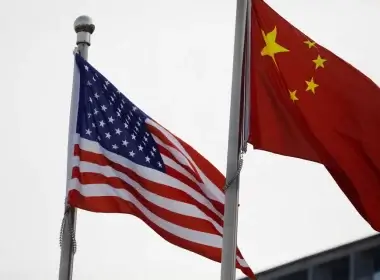 Chinese and U.S. flags flutter outside the building of an American company in Beijing, China January 21, 2021. REUTERS/Tingshu Wang/File Photo