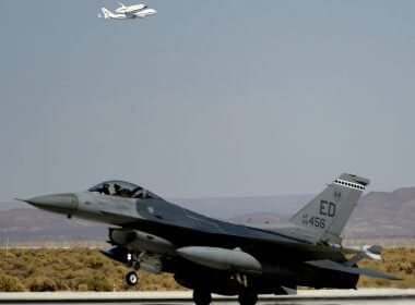 An F-16 fighter jet is seen in the foreground as the space shuttle Endeavour makes a flyby before landing at Edwards Air Force Base in California, September 20, 2012. REUTERS/Gene Blevins