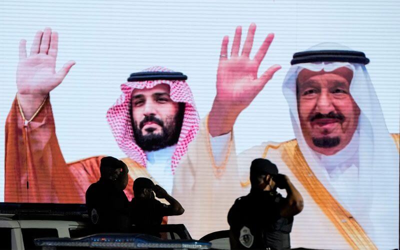 Saudi special forces troops salute in front of a screen displaying images Saudi King Salman, right, and Crown Prince Mohammed bin Salman after a military parade in preparation for the annual Hajj pilgrimage, in the Muslim holy city of Mecca, Saudi Arabia, July 3, 2022. (AP Photo/Amr Nabil, File)