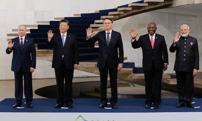 Russian President Vladimir Putin, Chinese leader Xi Jinping, Brazilian President Jair Bolsonaro, South African President Cyril Ramaphosa, and Indian Prime Minister Narendra Modi pose for a family picture during the 11th BRICS Summit in Brasilia, Brazil, on Nov. 14, 2019. (Sergio Lima/AFP via Getty Images)