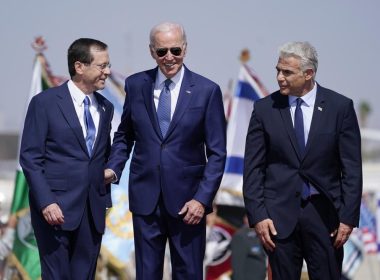 President Joe Biden stands with Israeli Prime Minister Yair Lapid, right, and President Isaac Herzog, left, after arriving at Ben Gurion Airport, Wednesday, July 13, 2022, in Tel Aviv. (AP Photo/Evan Vucci)