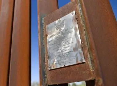 A welded plaque with the name of former President Donald J. Trump commemorates the construction of 100 miles of new wall along the border between the US and Mexico in Yuma, Arizona. (Patrick T. Fallon/Getty Images)