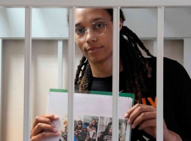 Olympian and WNBA basketball superstar Brittney Griner holds photographs standing inside a defendants' cage before a hearing at the Khimki Court, outside Moscow on July 27, 2022. Alexander Zemlianichenko/Pool/AFP via Getty Images