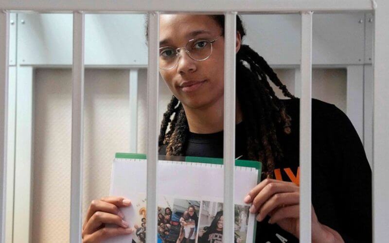 Olympian and WNBA basketball superstar Brittney Griner holds photographs standing inside a defendants' cage before a hearing at the Khimki Court, outside Moscow on July 27, 2022. Alexander Zemlianichenko/Pool/AFP via Getty Images