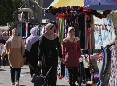 Women shop for clothes on the main road of an outdoor clothes market in Gaza City, Monday, July 25, 2022. AP