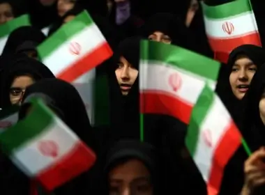 Schoolgirls wave Iranian flags during a ceremony marking the 33th anniversary of Ayatollah Ruhollah Khomeini's return from exile at Khomeini's mausoleum in Tehran on Feb. 1, 2012. (Photo By Atta Kenare/AFP Via Getty Images)