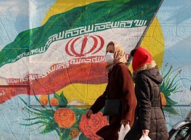 Iranians walk down a street in the capital Tehran on December 28, 2021. (Atta Kenare/AFP)