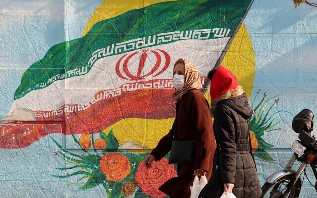 Iranians walk down a street in the capital Tehran on December 28, 2021. (Atta Kenare/AFP)