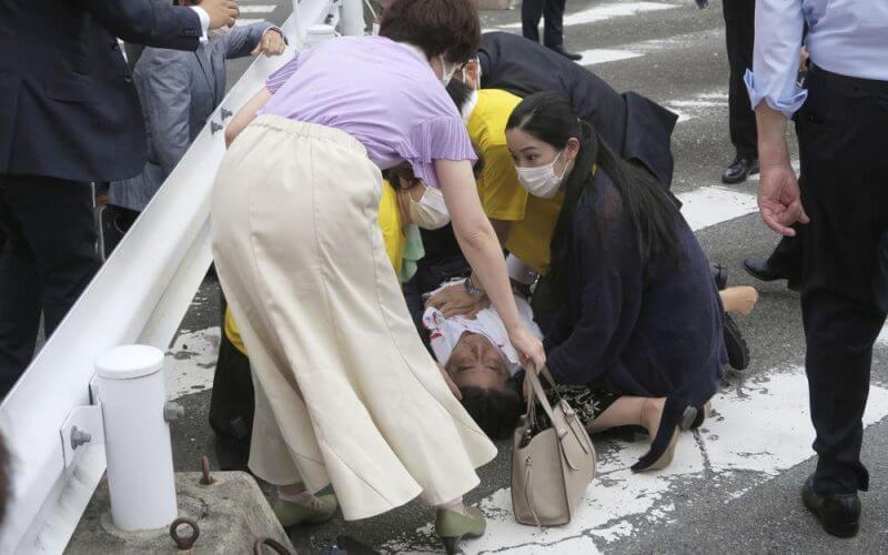 Japan’s former Prime Minister Shinzo Abe, center, falls on the ground in Nara, western Japan Friday, July 8, 2022. (Kyodo News via AP)