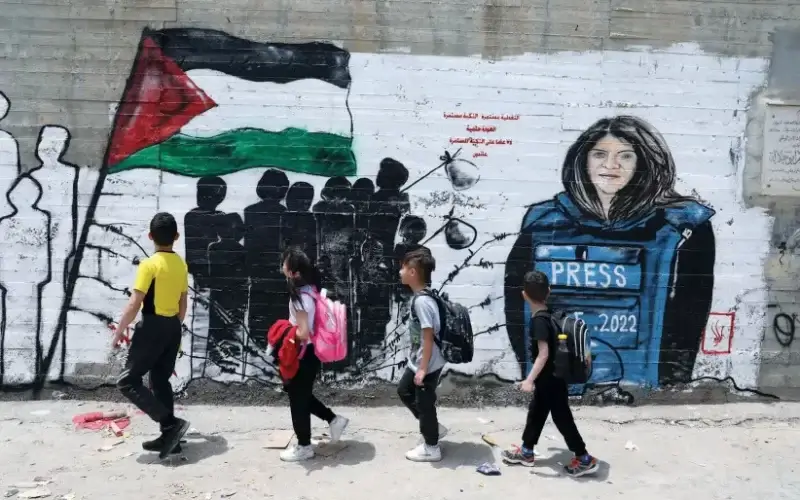 Palestinian children walk past a mural of Al Jazeera journalist Shireen Abu Akleh in Bethlehem. (photo credit: WISAM HASHLAMOUN/FLASH90)