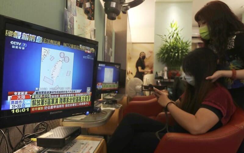 A TV news shows a map marking the areas where China is conducting live fire exercises near Taiwan, at a beauty salon in Taipei, Taiwan, Thursday, Aug 4, 2022. AP