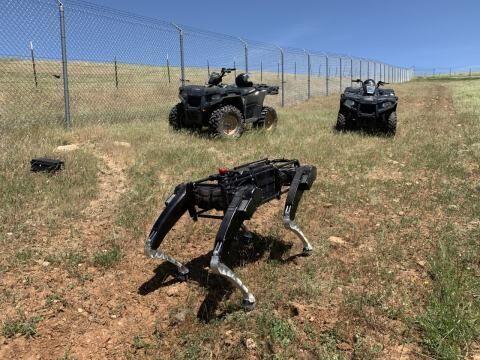 A Ghost Robotics Automated Ground Surveillance Vehicle (AGSV) stands alongside ATVs in El Paso, Texas. Image courtesy of U.S. Customs and Border Protection