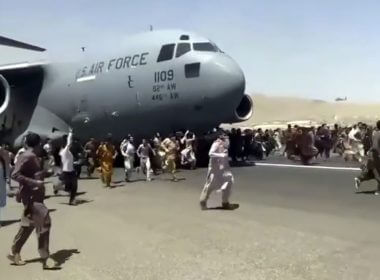 People run alongside a U.S. Air Force C-17 transport plane as it moves down a runway of the Kabul airport in Afghanistan on Monday.Verified UGC via AP