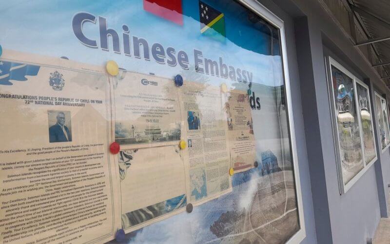 A display case of photos is seen outside the Chinese Embassy in Honiara, Solomon Islands on April 2, 2022. A Chinese state-owned company is negotiating to buy a forestry planation with a deep-water port and World War II airstrip in Solomon Islands, as concerns continue that China wants to establish a naval foothold in the South Pacific country. (AP Photo/Charley Piringi, File)