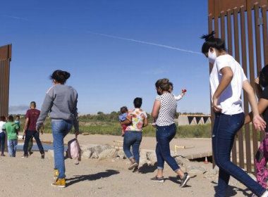 In this Tuesday, June 8, 2021, photo, a group of Brazilian migrants make their way around a gap in the U.S.-Mexico border in Yuma, Ariz., seeking asylum in the United States after crossing over from Mexico. Eugene Garcia / AP