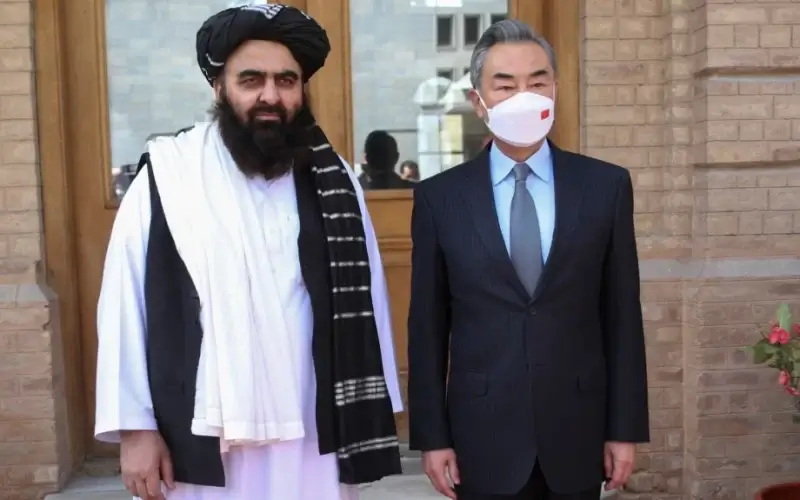 In this photo released by Xinhua News Agency, Chinese Foreign Minister Wang Yi poses for photos with Amir Khan Muttaqi, acting foreign minister of the Afghan Taliban's caretaker government, in Kabul, March 24, 2022. (Saifurahman Safi/Xinhua via AP)