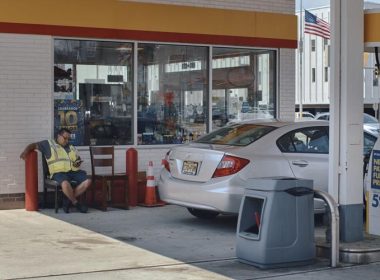 An employee checks his phone as he waits to serve a customer at a gas station on Wednesday in Jersey City, New Jersey. Consumers are feeling the pinch of inflation despite falling gas prices. Andres Kudacki / AP photo