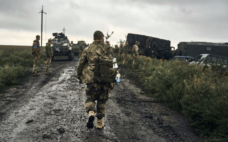 Ukrainian soldiers stand on the road in the freed territory of the Kharkiv region, Ukraine, Monday, Sept. 12, 2022. AP