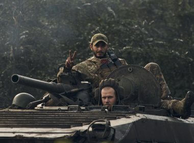 A Ukrainian soldier shows a V-sign atop a vehicle in Izium, Kharkiv region, Ukraine, Tuesday, Sept. 13, 2022. AP