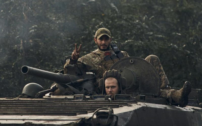 A Ukrainian soldier shows a V-sign atop a vehicle in Izium, Kharkiv region, Ukraine, Tuesday, Sept. 13, 2022. AP