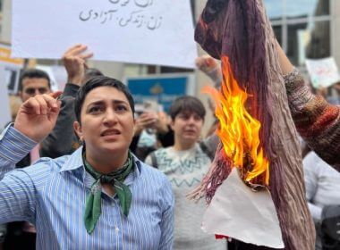 Demonstrators burn a scarf at a protest against the Iranian government on Sunday. The protest was inspired by the death of Mahsa Amini, a 22-year-old woman who'd been arrested by Iran's morality police for allegedly wearing her hijab improperly. (David Bates/CBC)