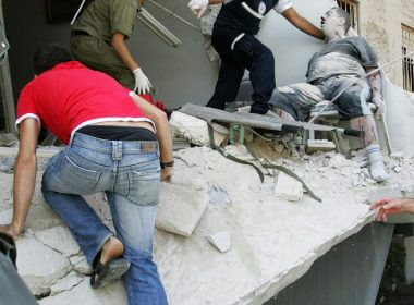 Rescue workers evacuate a seriously wounded man from a building directly hit by a rocket fired from Lebanon in the northern Israeli city of Haifa, July 17, 2006.