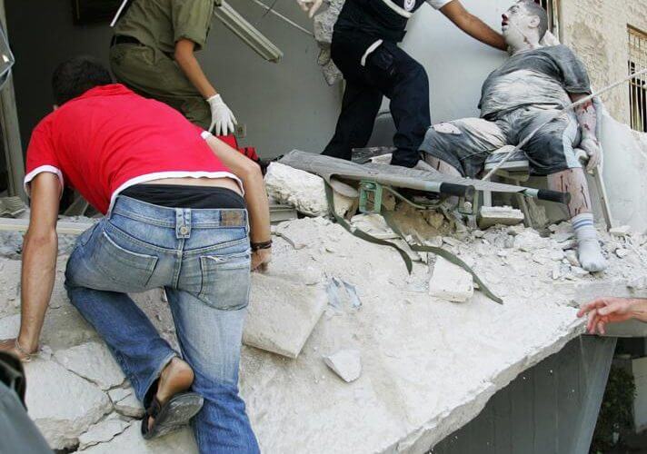 Rescue workers evacuate a seriously wounded man from a building directly hit by a rocket fired from Lebanon in the northern Israeli city of Haifa, July 17, 2006.