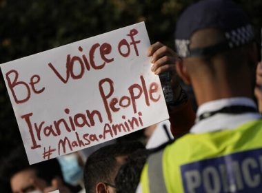 Demonstrators hold placards outside the Iranian Embassy in London, September 25, 2022. (AP Photo/Alastair Grant)