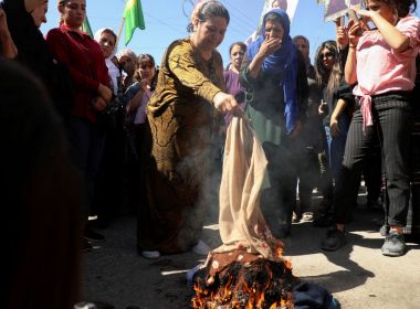 Women burn headscarves during a protest over the death of 22-year-old Kurdish woman Mahsa Amini in Iran, in the Kurdish-controlled city of Qamishli, northeastern Syria September 26, 2022. REUTERS/Orhan Qereman