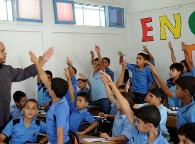 Palestinian boys raise their hands at a school in the Gaza Strip supported by the United Nations Relief and Works Agency for Palestine Refugees in the Near East (UNRWA) in September 2011. Credit: U.N. Photo/Shareef Sarhan.