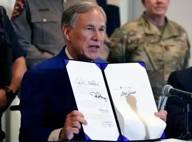 Texas Gov Greg Abbott displays a bill he signed into law that provides additional funding for security at the U.S.-Mexico border Friday, Sept. 17, 2021, in Fort Worth. LM Otero | AP