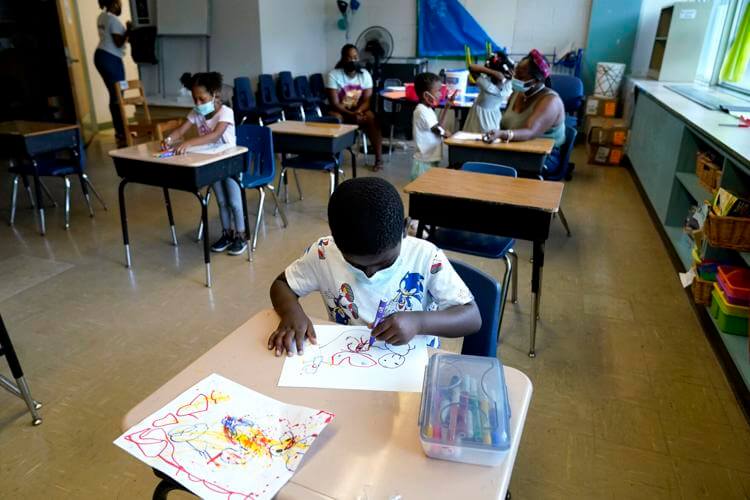 Caleb Taylor, 5, front, works on his art work during a class at Chalmers Elementary school in Chicago, Wednesday, July 13, 2022. AP Photo/Nam Y. Huh