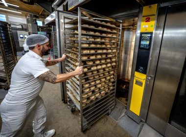 An employee pushes bread rolls into one of the gas heated ovens in the producing facility in Cafe Ernst in Neu Isenburg, Germany, Monday, Sept. 19, 2022. AP