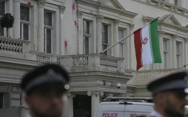 Police stand guard outside the Iranian Embassy after a small group of protesters threw paint at the building in London, Sunday, Sept. 25, 2022. AP