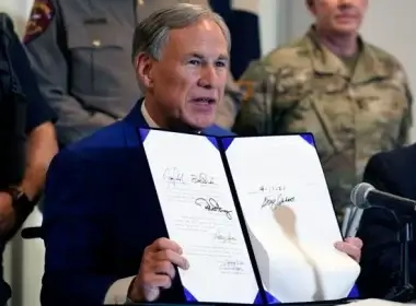 Texas Gov Greg Abbott displays a bill he signed into law that provides additional funding for security at the U.S.-Mexico border Friday, Sept. 17, 2021, in Fort Worth. AP