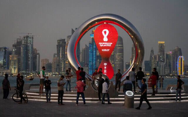 People gather around the official countdown clock showing remaining time until the kick-off of the World Cup 2022, in Doha, Qatar, November 25, 2021. (AP/Darko Bandic)