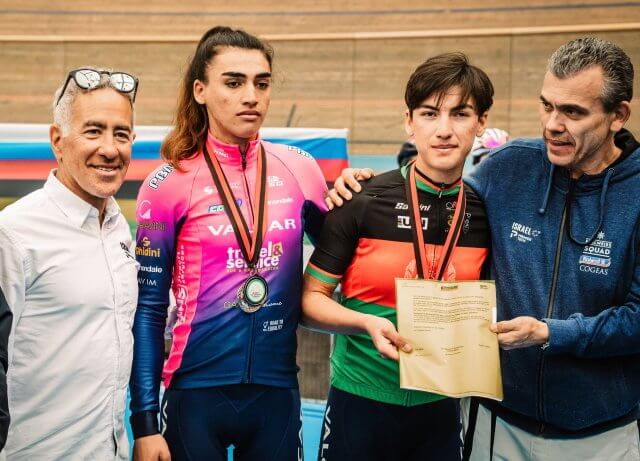 Afghanistan's national cycling champion Fariba Hashimi (2R) and her older sister Yulduz (2L) receive their contracts from the owner of Women’s WorldTour team Israel – Premier Tech Roland, Sylvan Adams, in Aigle, Switzerland, Oct. 23, 2022. (Photo: Israel – Premier Tech/Twitter)