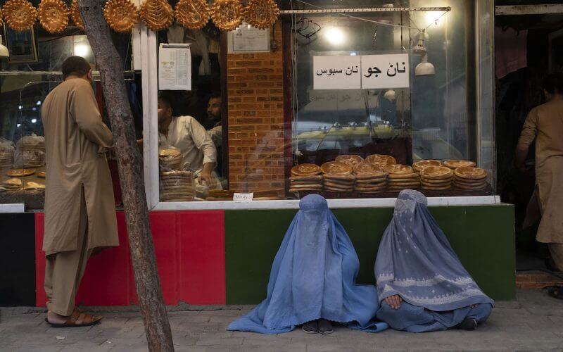 Afghan women in blue burqas wait outside the city’s bakeries, waiting for any passerby to buy them bread, Kabul, Afghanistan, July 21, 2022. (Photo: Alfred Yaghobzadeh/ABACAPRESS.COM)