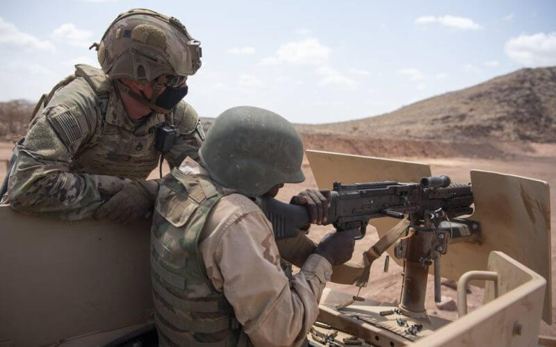 U.S. Army Staff Sgt. Matthew Hugelmann watches as a Djiboutian soldier fires a mounted machine gun from a Humvee on Oct. 28, 2020, at an undisclosed location in the African nation. (Tech. Sgt. Peter Thompson/U.S. Air Force)