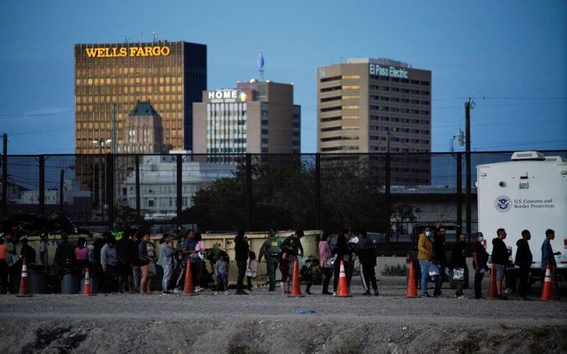 Asylum-seeking migrants wait in line to be processed by U.S. Border Patrol after crossing the border to El Paso, Texas, U.S., as seen from Ciudad Juarez, Mexico, October 3, 2022. REUTERS/Paul Ratje